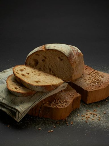 Sliced sourdough bread on a rustic surface, showcasing homemade culinary artistry.