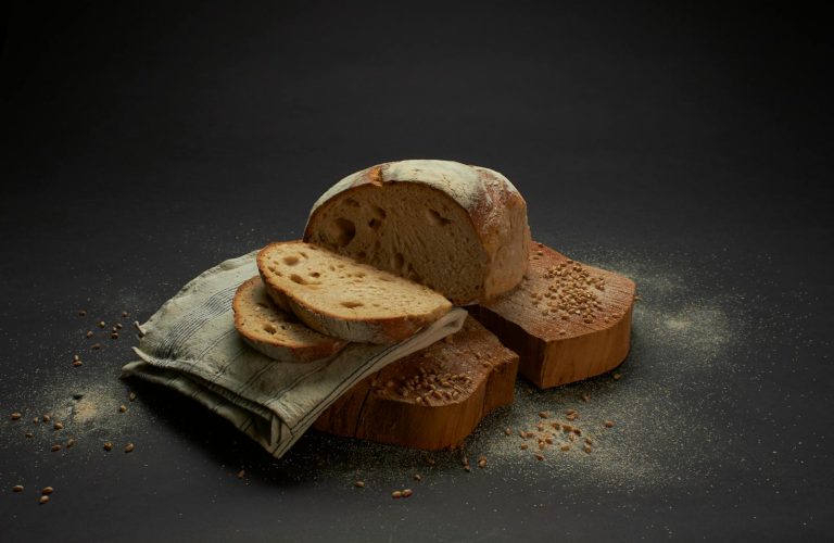 Sliced sourdough bread on a rustic surface, showcasing homemade culinary artistry.