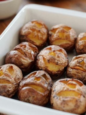 Tray of baked potatoes with carved Halloween faces, perfect for festive meals.